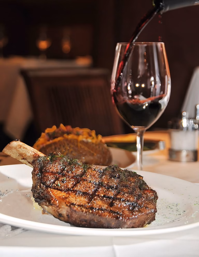 USDA Prime bone-in ribeye steak paired with red wine at Bascom's Chop House in Clearwater, FL