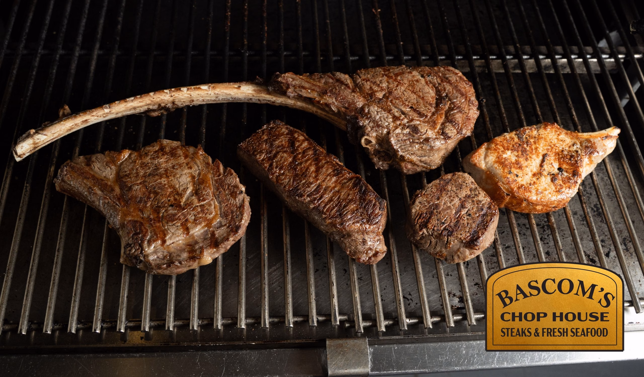 Assortment of premium steaks cooking on the grill at Bascom’s Chop House in Clearwater